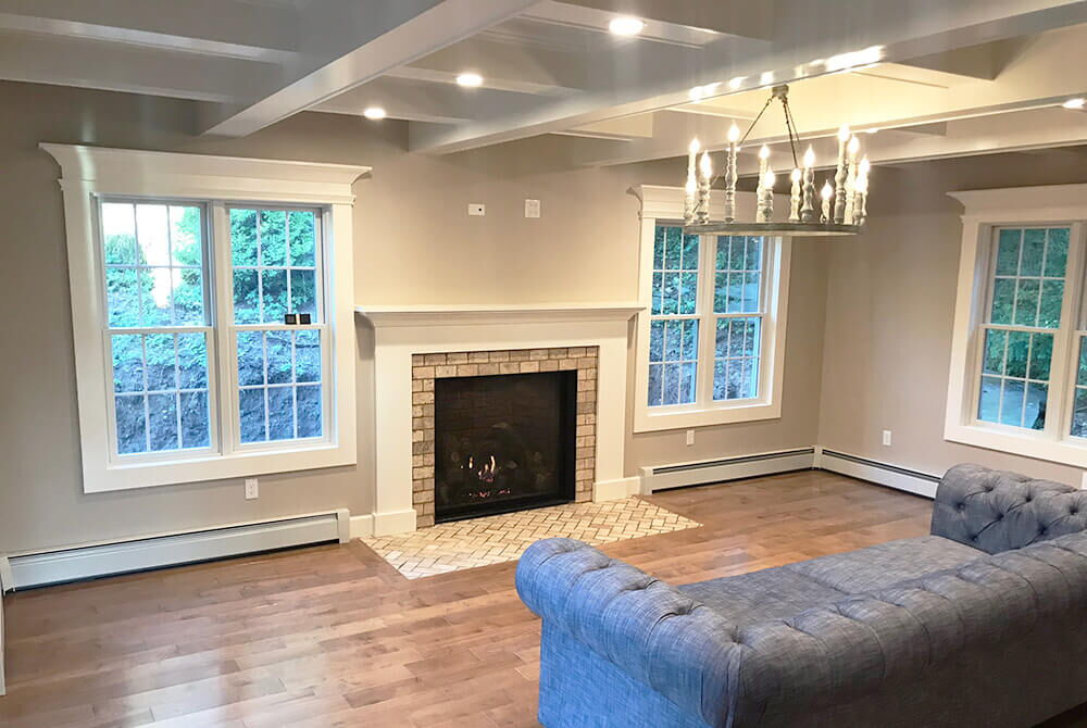 living room with fireplace and recessed lighting and blue couch and chandelier